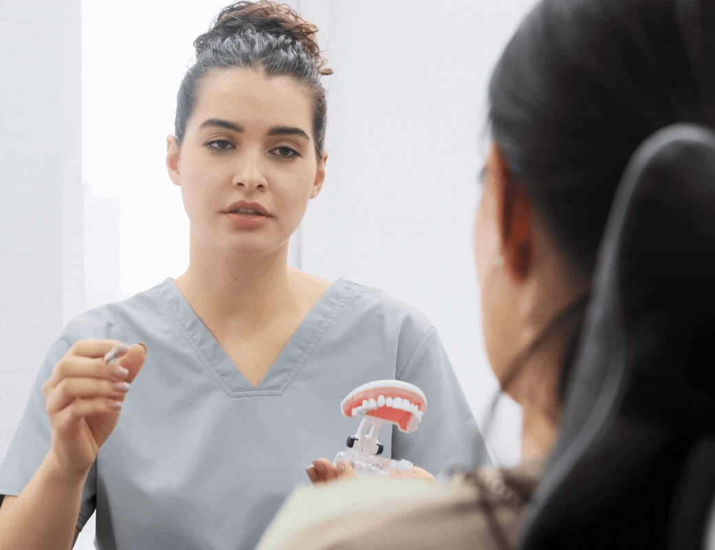 Une dentiste explique les prothèses dentaires à une patiente